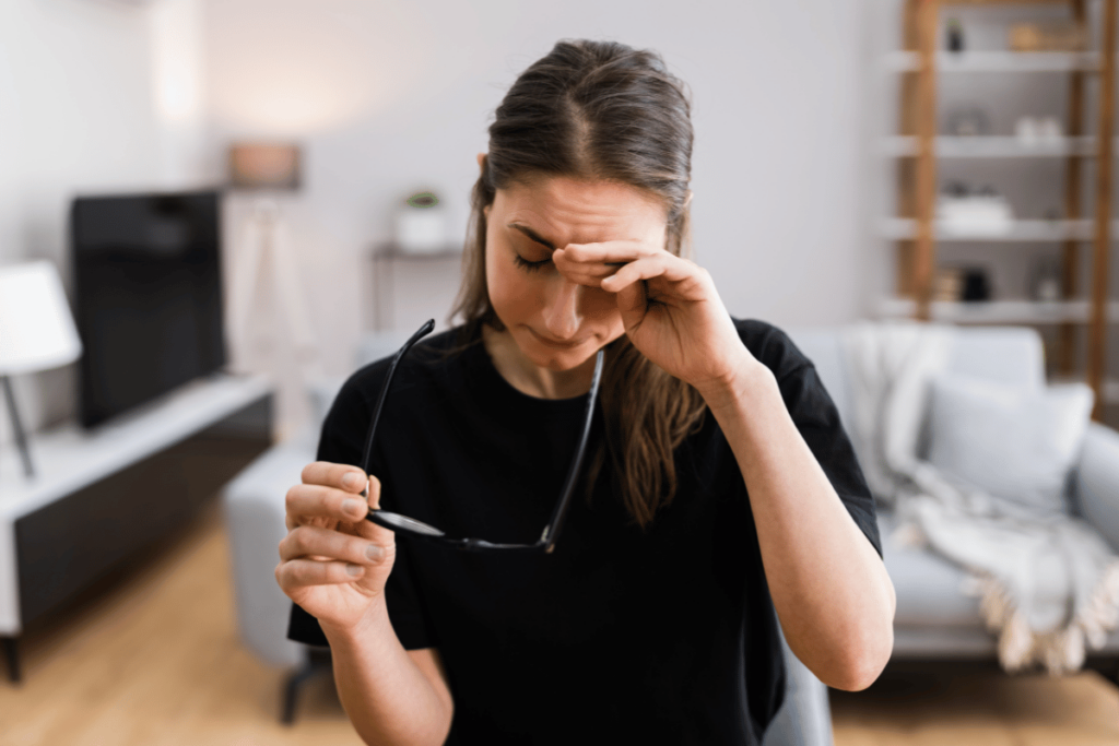 young woman holding her hand to her eye due to discomfort