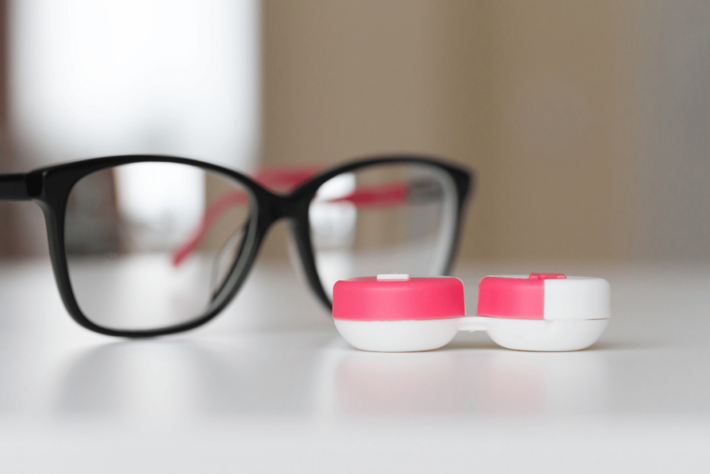 close-up of a pair of glasses and a contact lens case